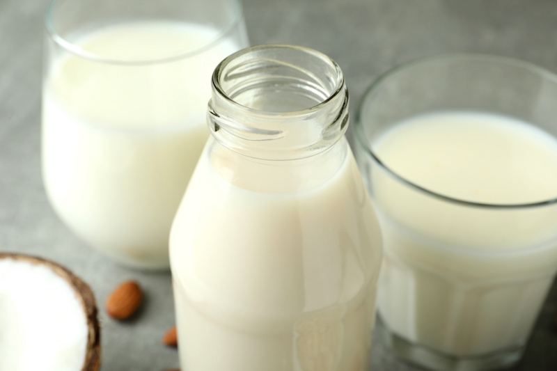 lait de coco et lait d'amande en bouteille et verre